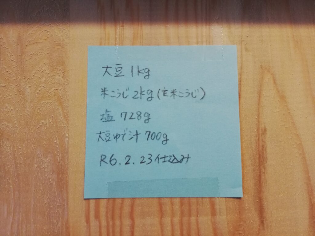 大豆1kg、玄米麹2kg、塩728kg、大豆ゆで汁700g、R6.2.23仕込みと書かれた付箋