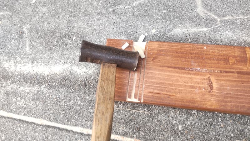 丸ノコで削った溝を金づちで叩いているところ